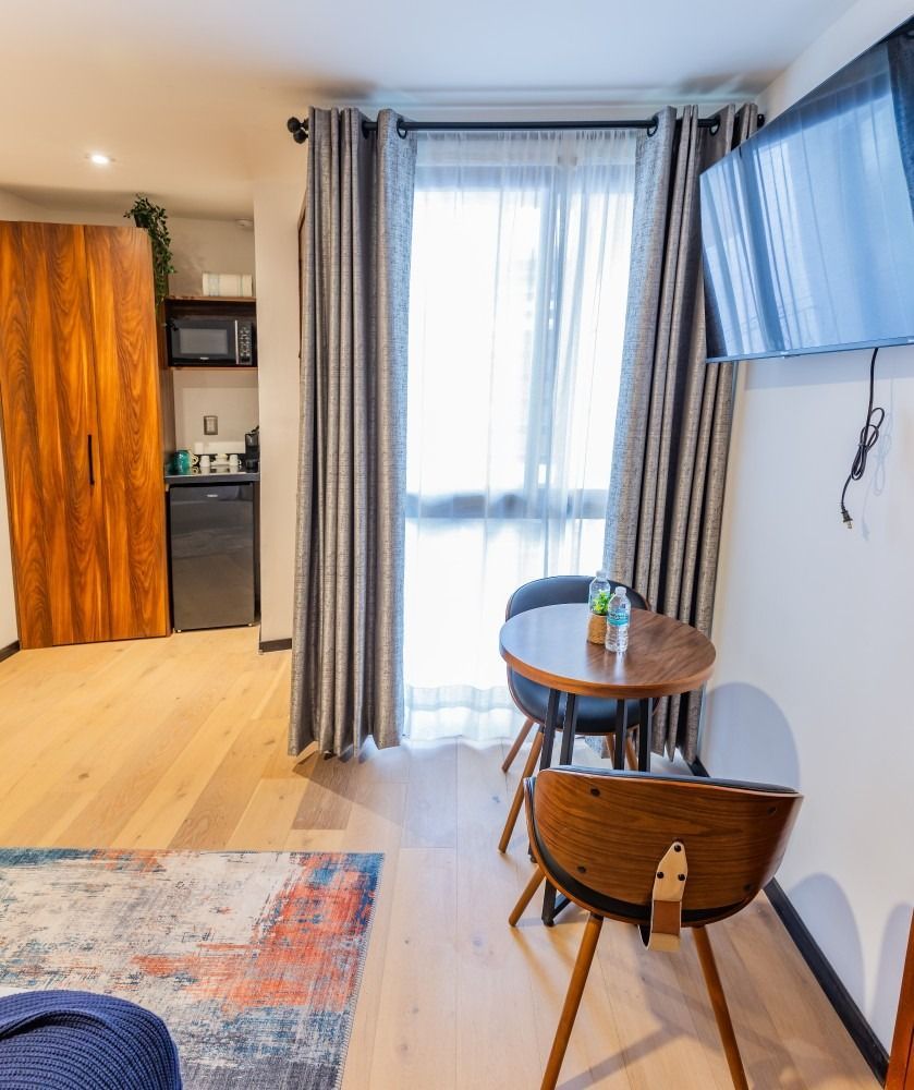 Una sala de estar con una mesa y sillas y un televisor de pantalla plana.