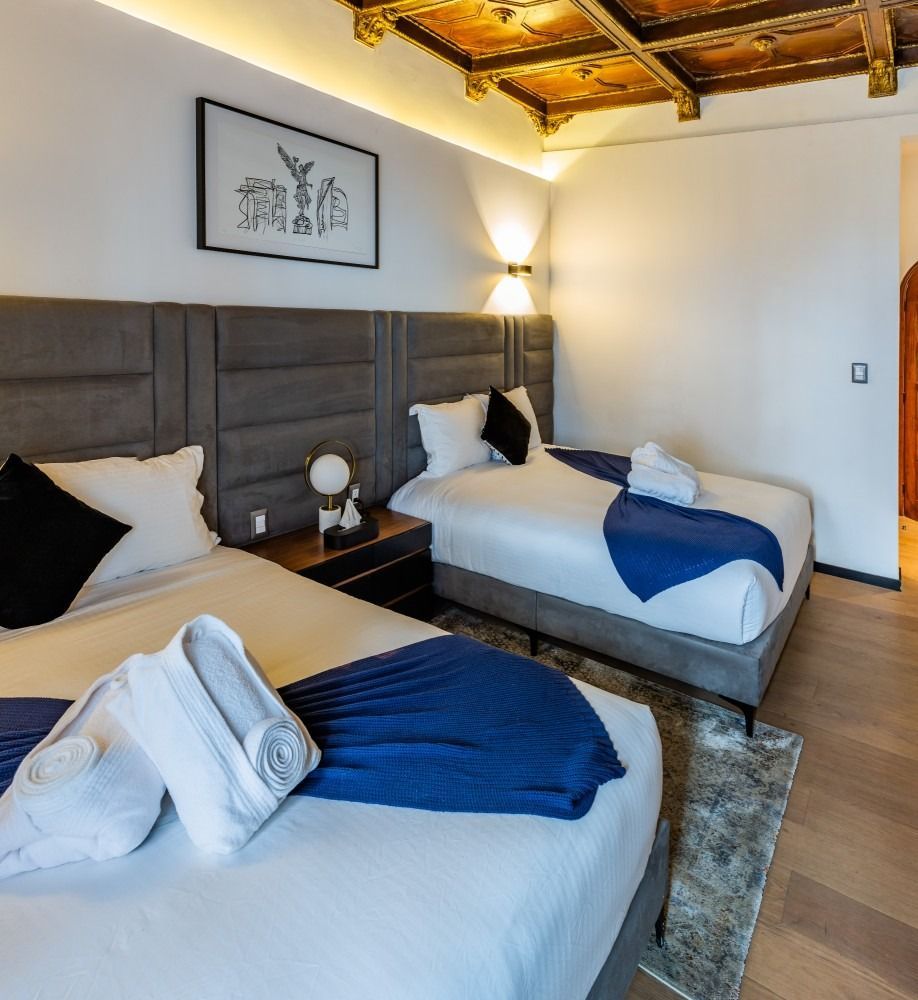 A hotel room with two beds and a picture on the wall