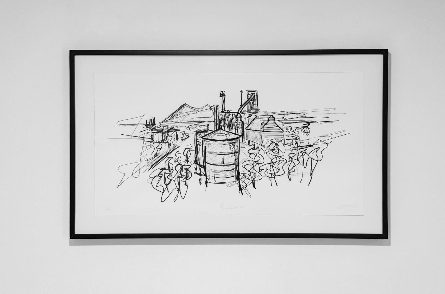 Un dibujo en blanco y negro de una fábrica está colgado en una pared.