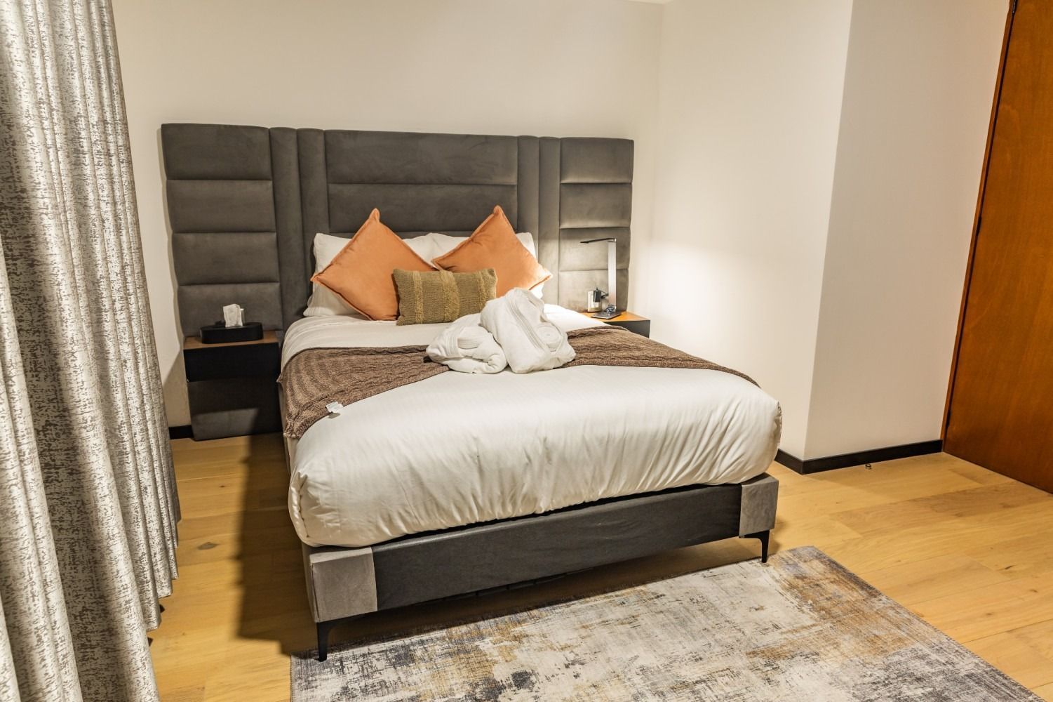 Una habitación de hotel con una cama grande y una alfombra.