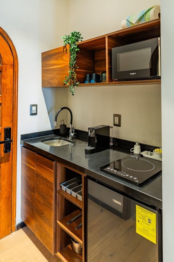 A small kitchen with a sink , stove , microwave and refrigerator.