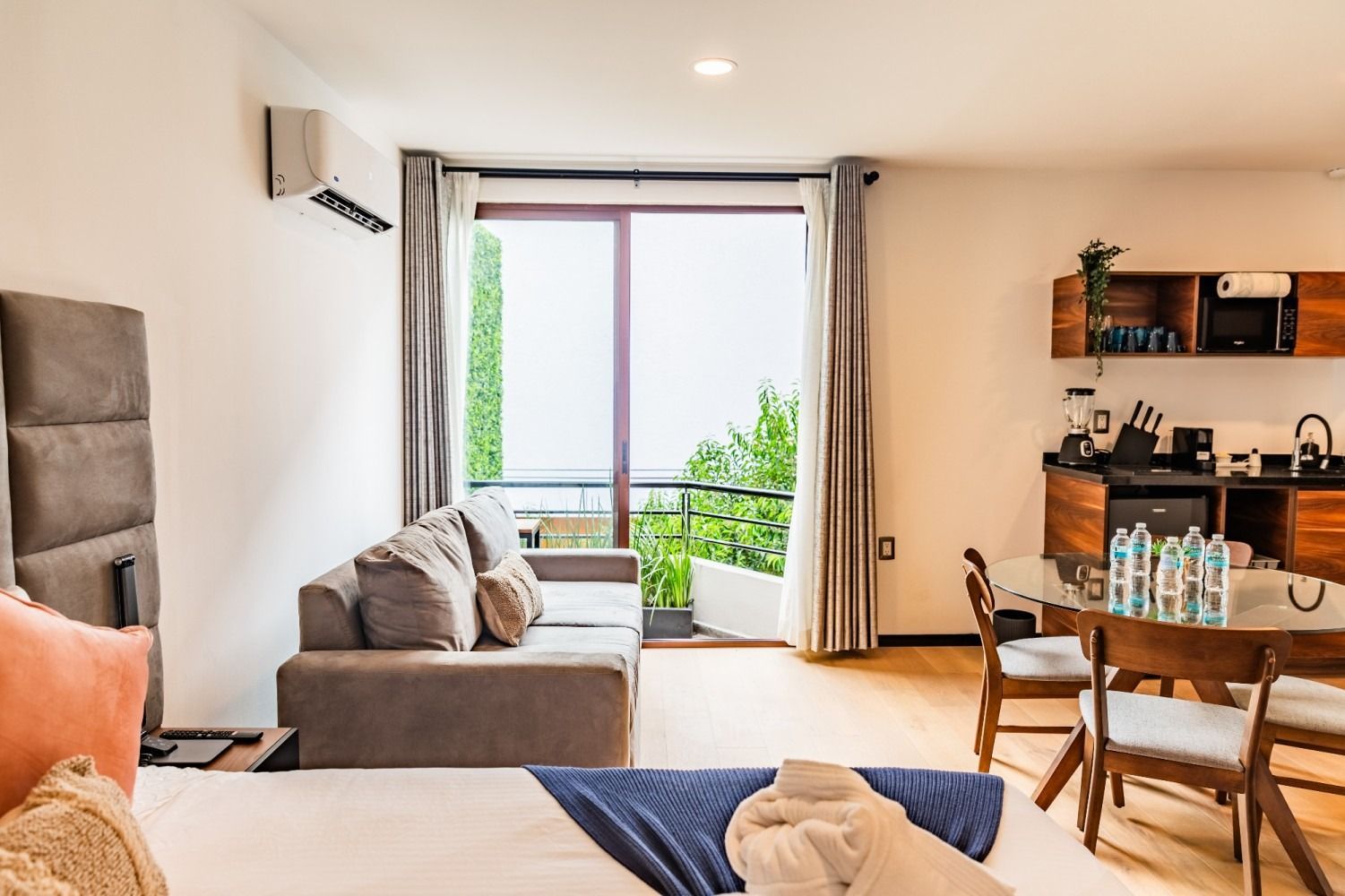 Una habitación de hotel con una cama, un sofá, una mesa y sillas.