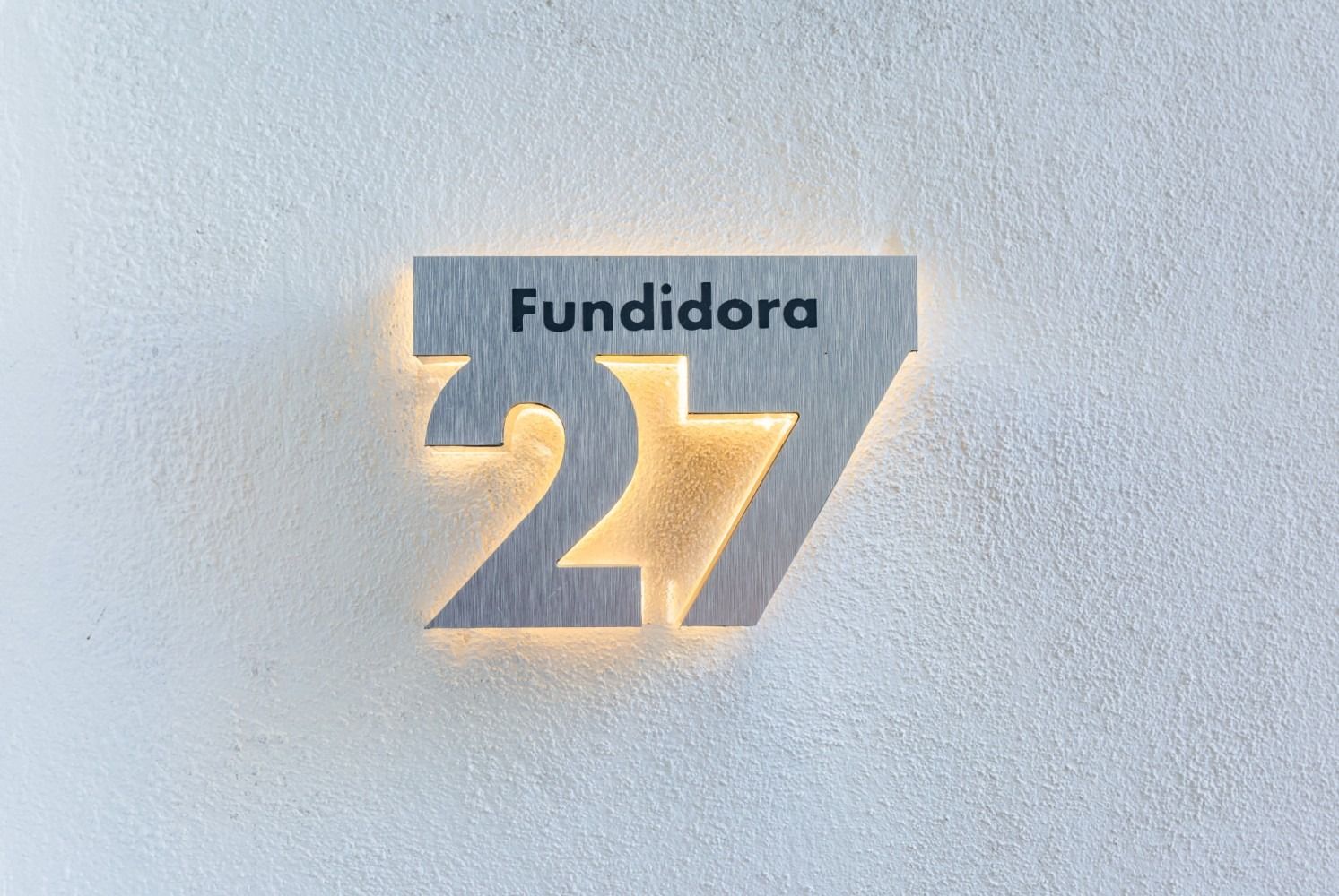 El número 27 está en una pared blanca.