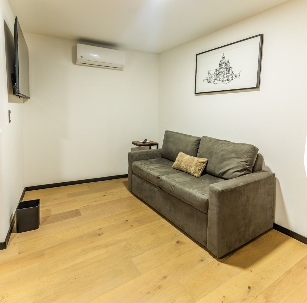 Una sala de estar con un sofá y un cuadro en la pared.
