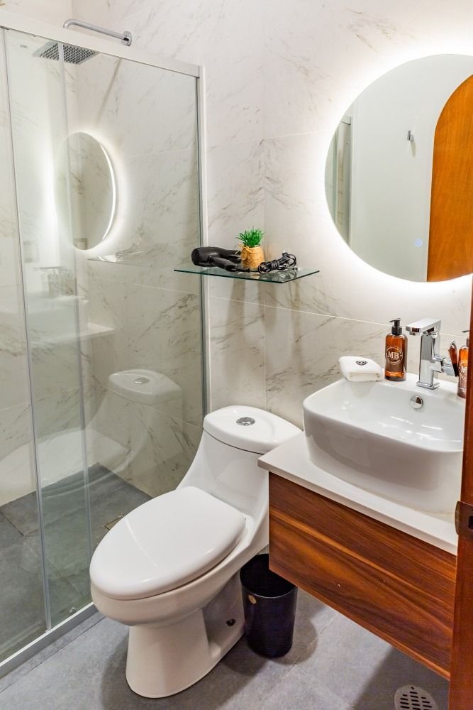 A bathroom with a toilet , sink , and shower.