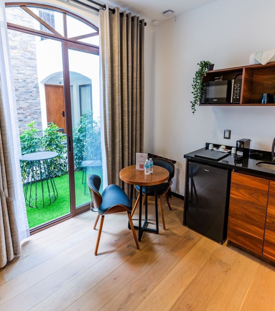 There is a table and chairs in the room with a sliding glass door.