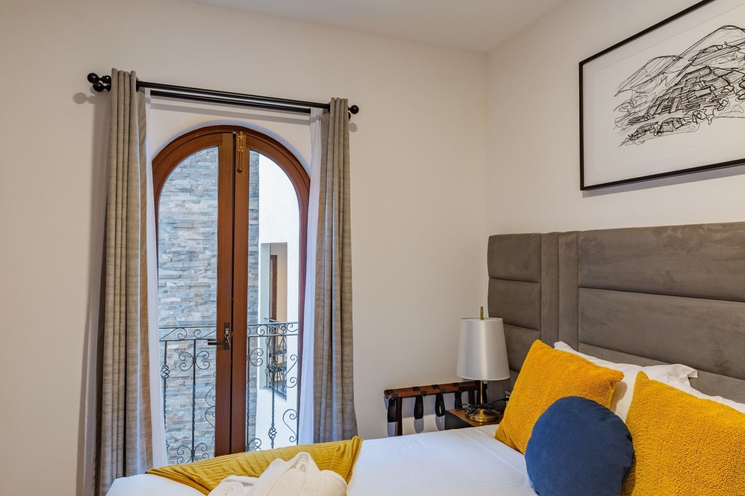 Un dormitorio con una cama grande y un balcón.