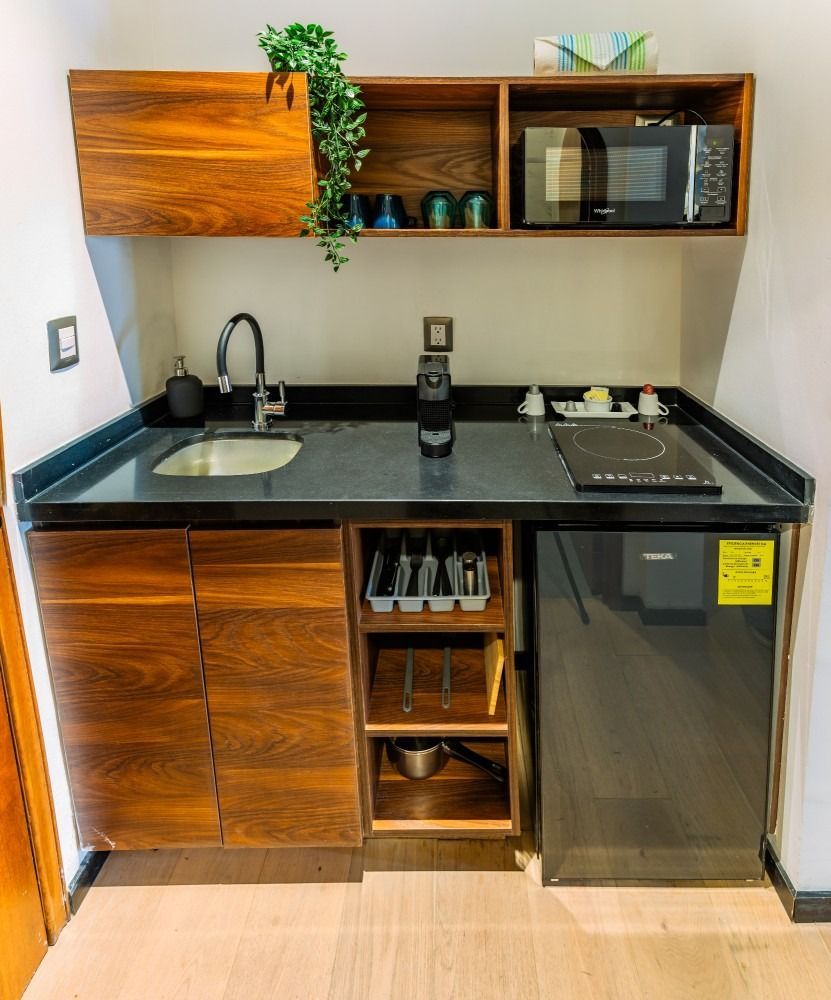 A small kitchen with a sink , stove , microwave and dishwasher.