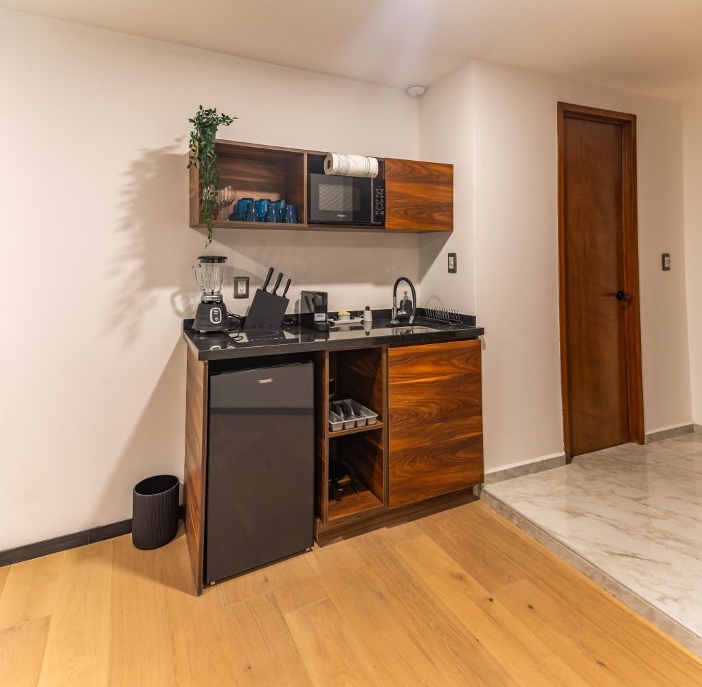 Una pequeña cocina con gabinetes de madera y refrigerador.
