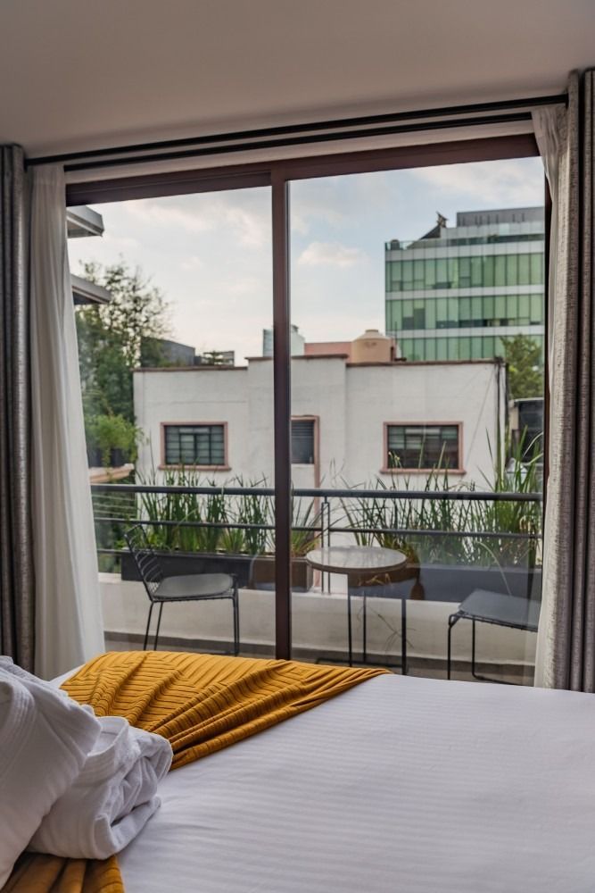 Un dormitorio con una puerta corrediza de vidrio que conduce a un balcón.
