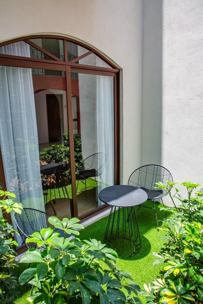 A balcony with a table and chairs in front of a sliding glass door.