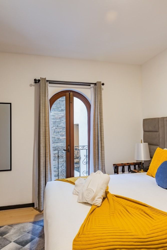Un dormitorio con una cama king size y un balcón.