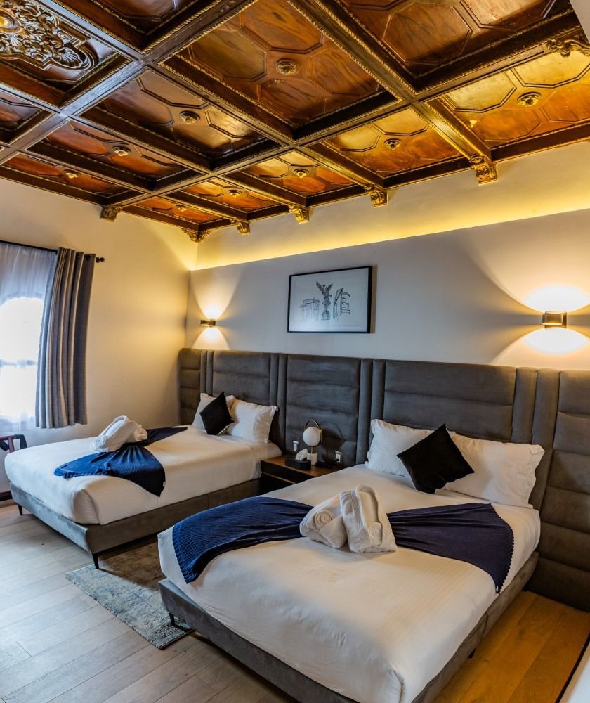 A hotel room with two beds and a wooden ceiling