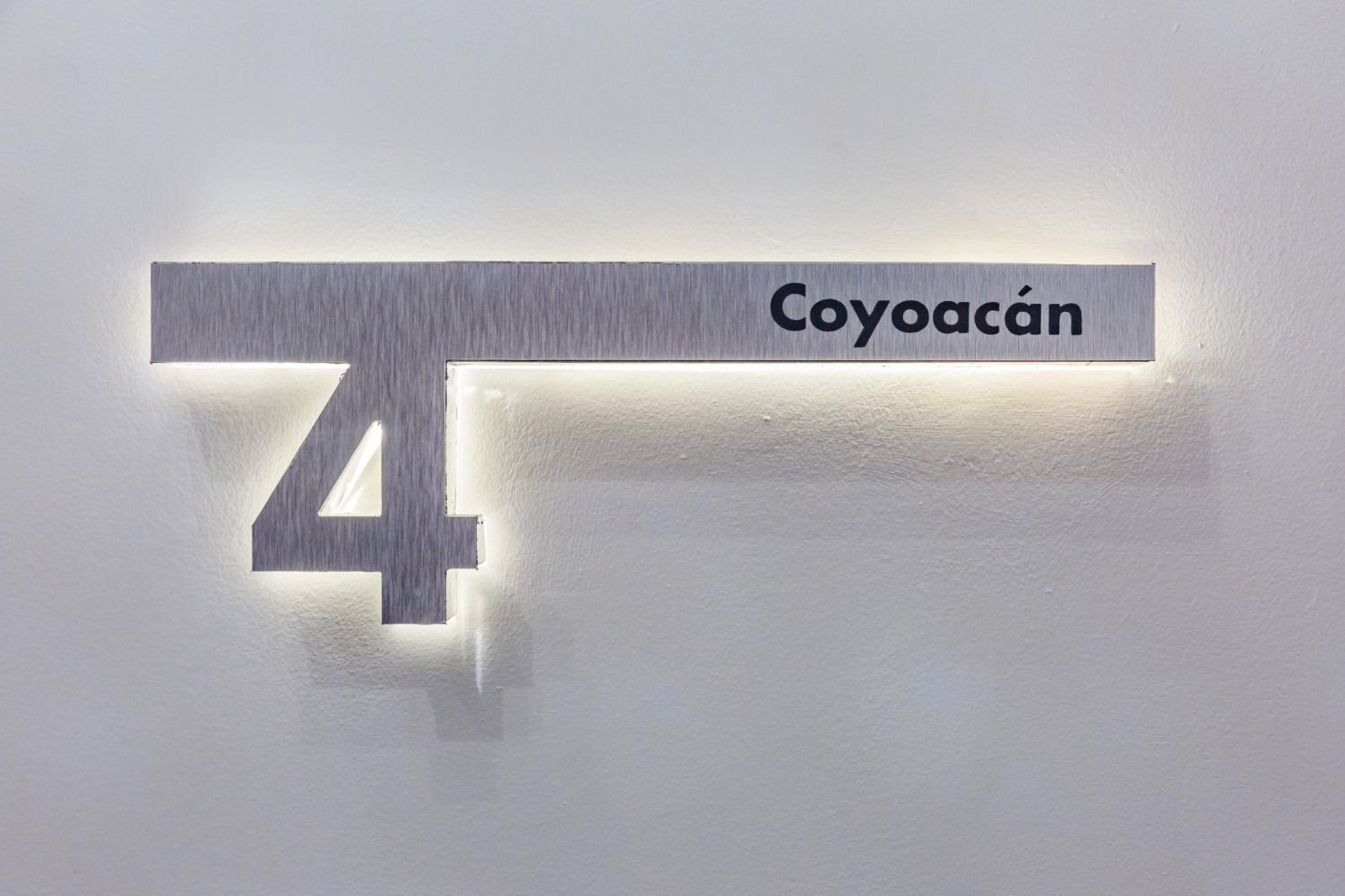 A sign on a wall with the number four and the name coyoacan.