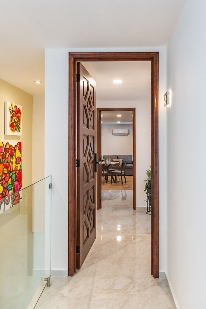 Un pasillo con una puerta de madera que conduce a un comedor.