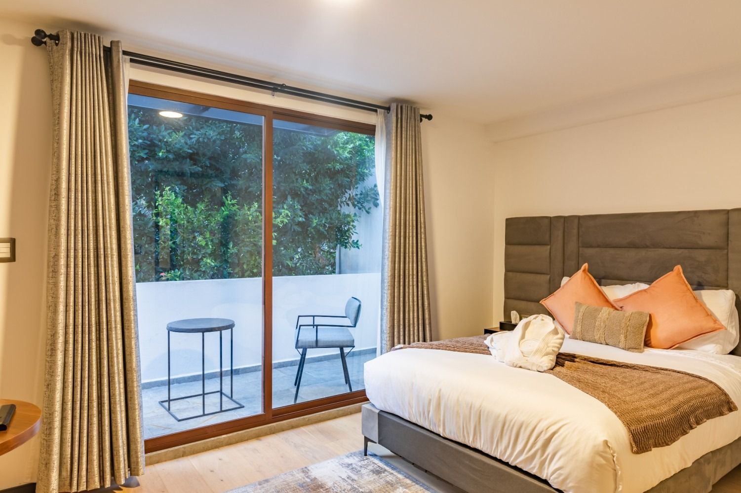 Un dormitorio con una cama grande y una puerta corrediza de vidrio que conduce a un balcón.