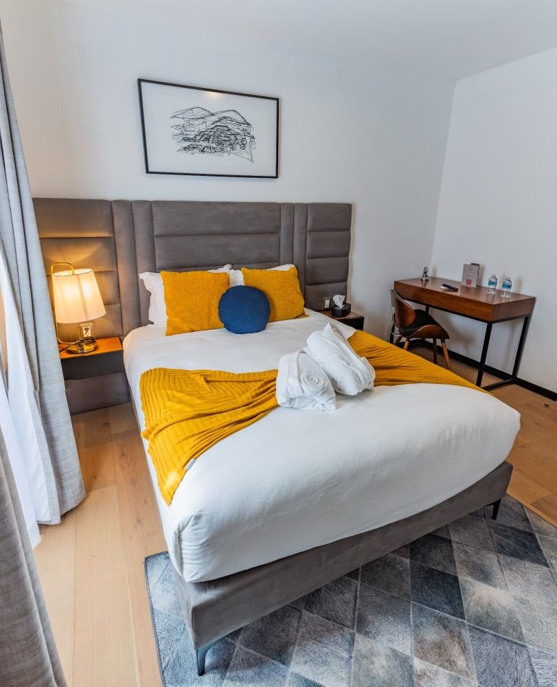 Una habitación de hotel con una cama tamaño king y un escritorio.