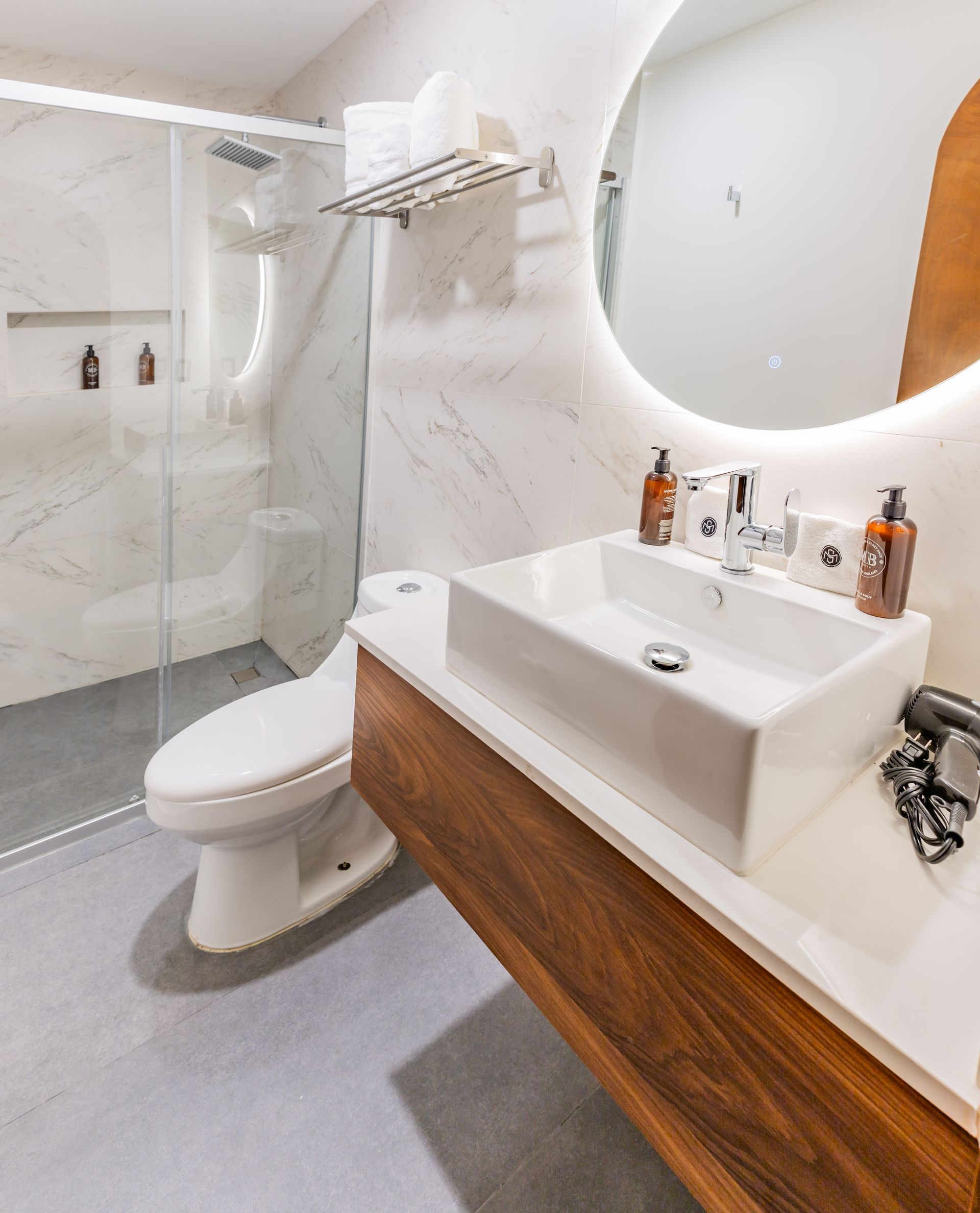 Un baño con inodoro, lavabo, espejo y ducha.