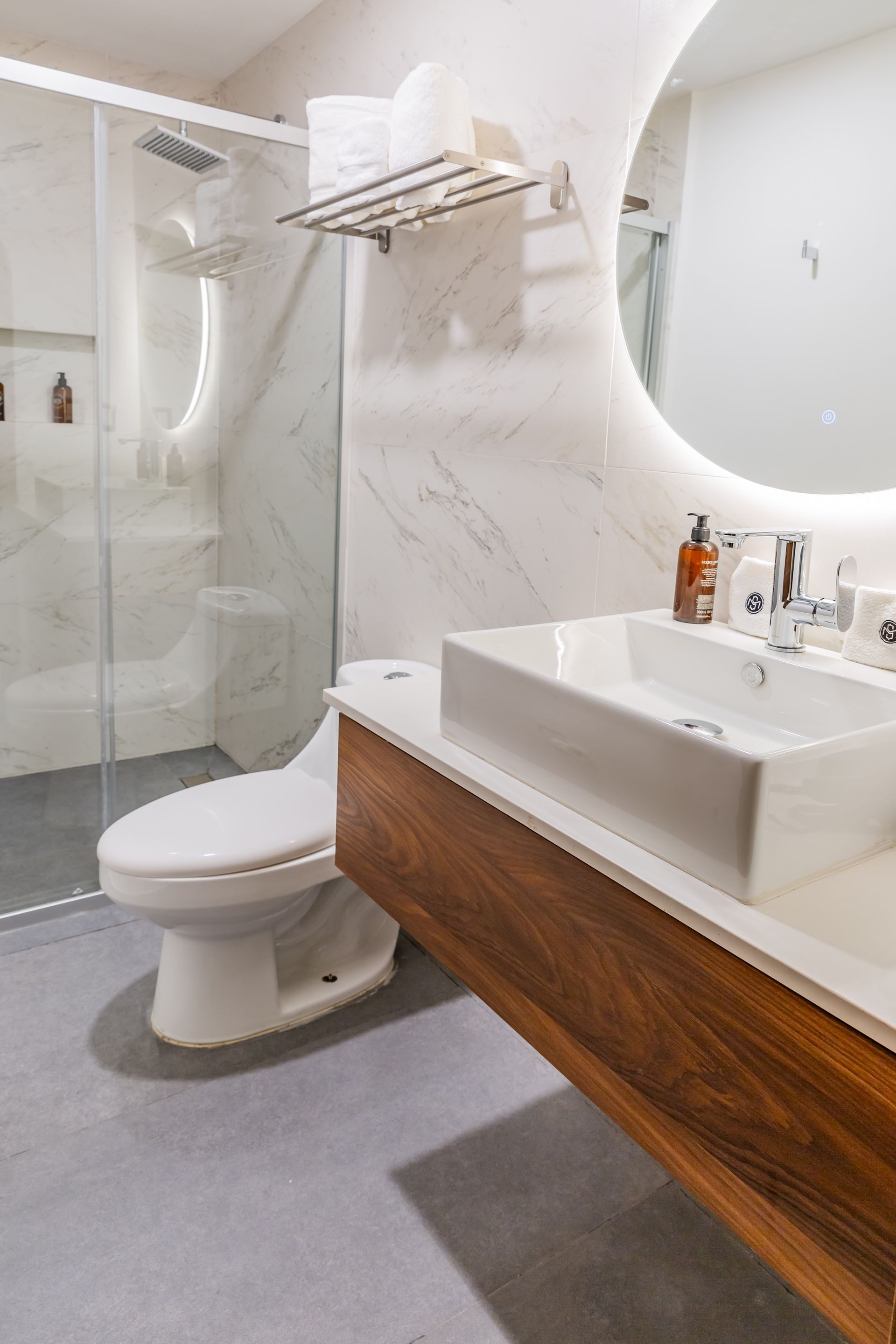 Un baño con inodoro, lavabo, espejo y ducha.