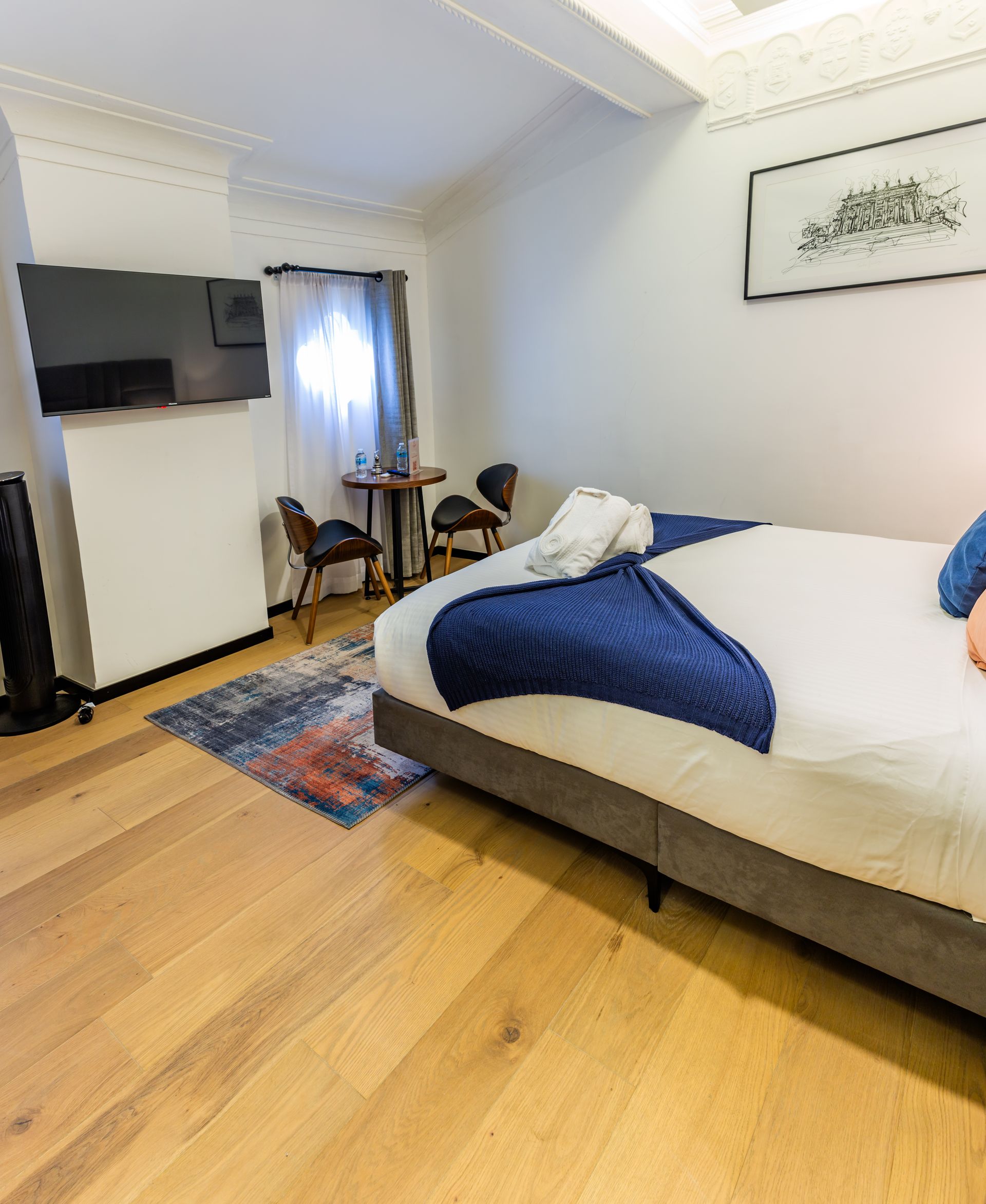 Una habitación de hotel con una cama, mesa y sillas.