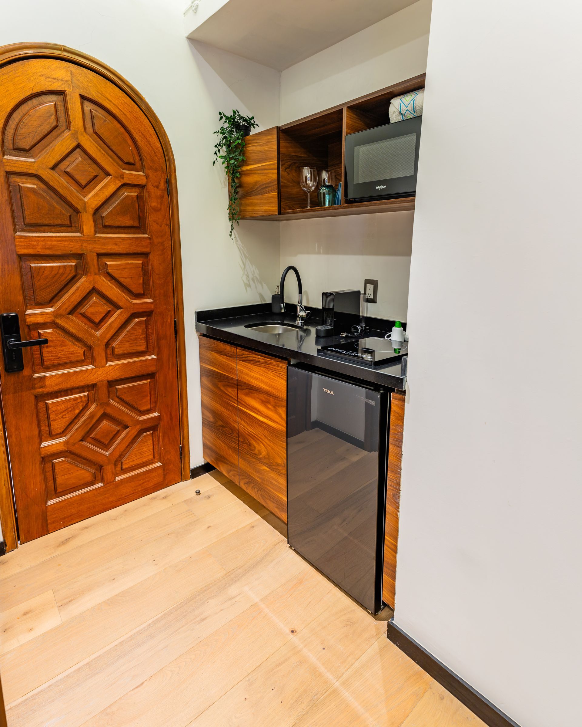 Una cocina con puerta de madera y lavavajillas negro.