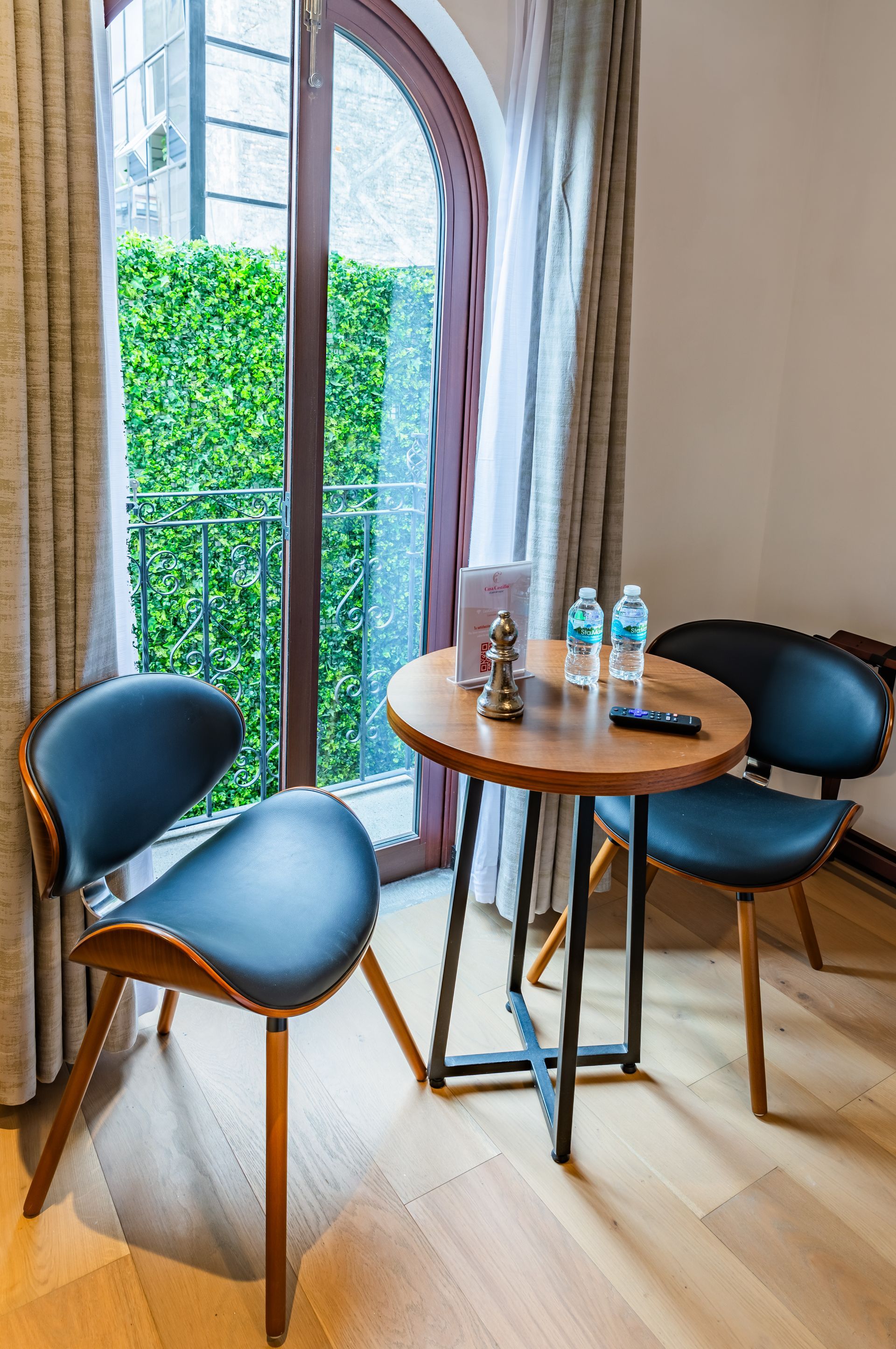 Una habitación con una mesa y sillas frente a una ventana.