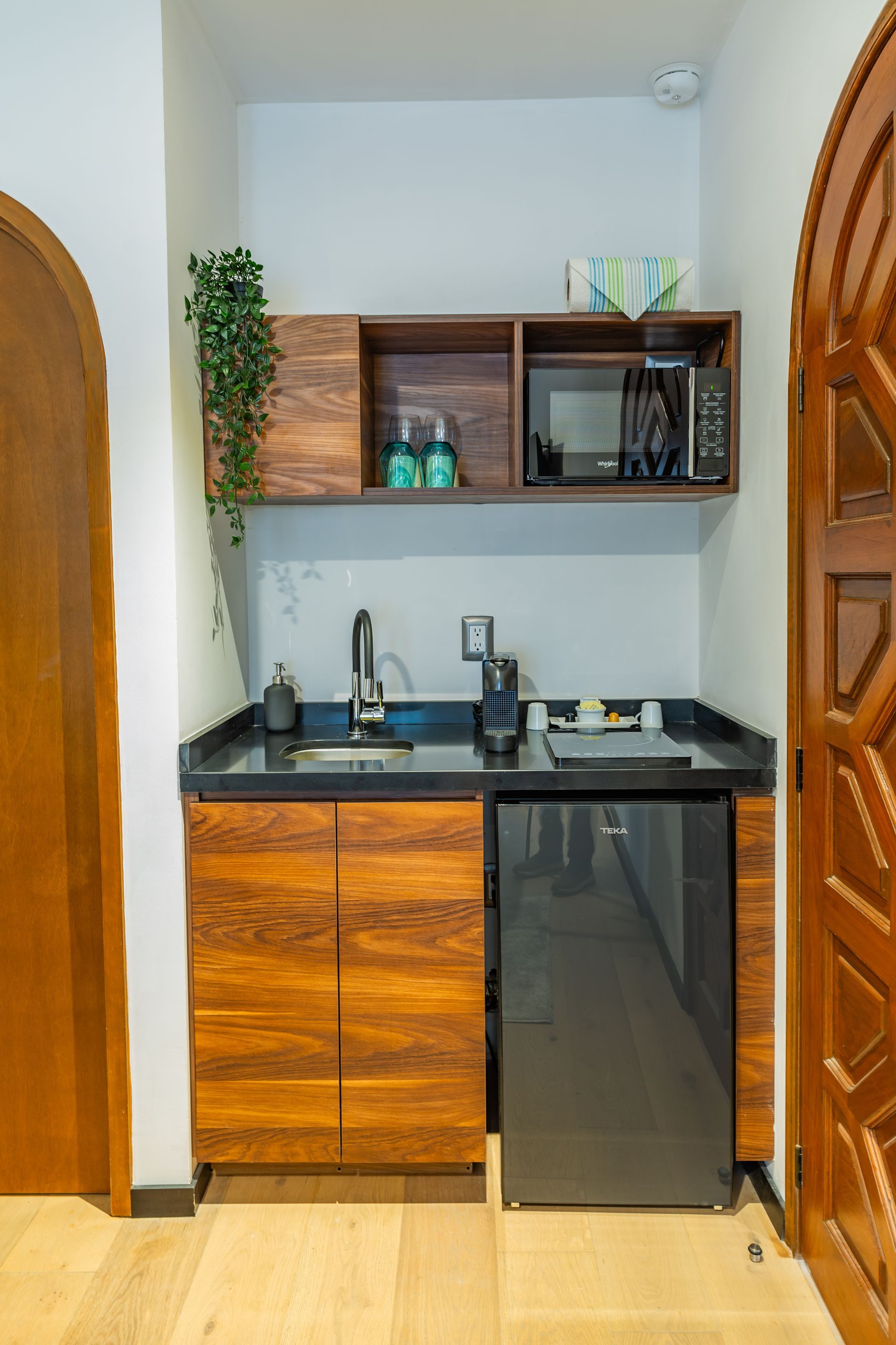 Una pequeña cocina con fregadero, frigorífico y microondas.