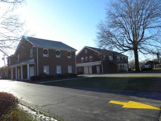 Two brick buildings are sitting next to each other on the side of a road.