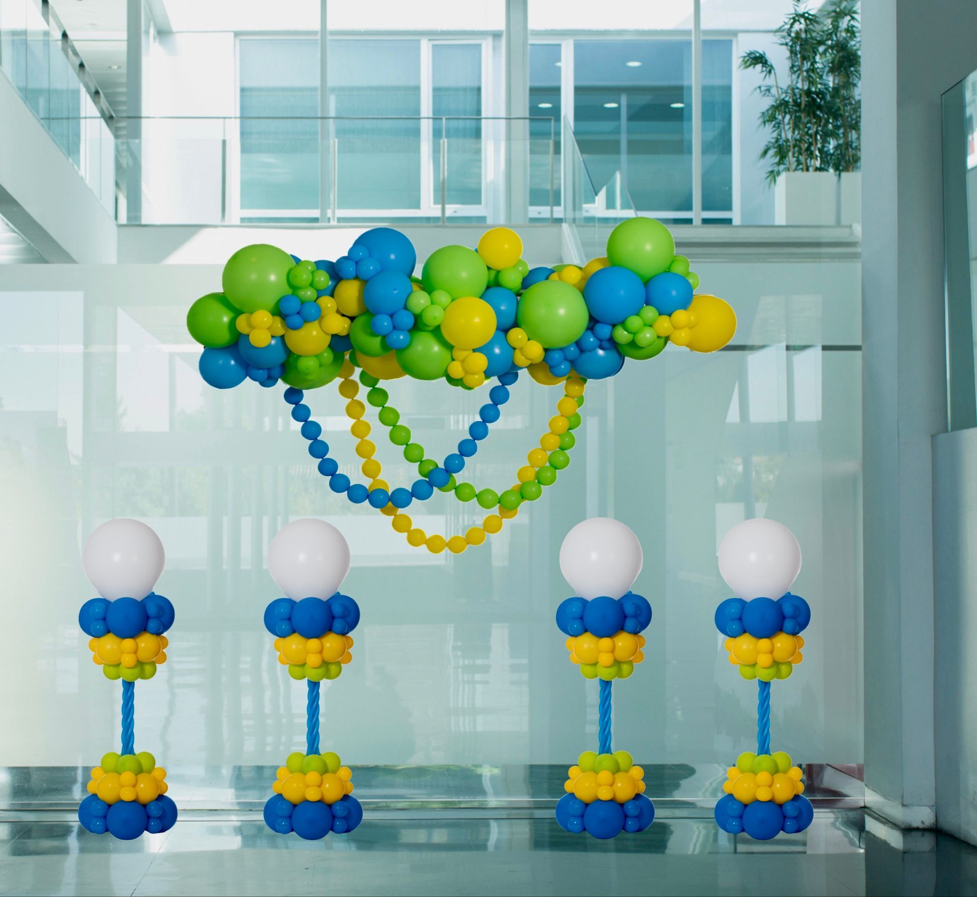 A bunch of blue and yellow balloons hanging from the ceiling