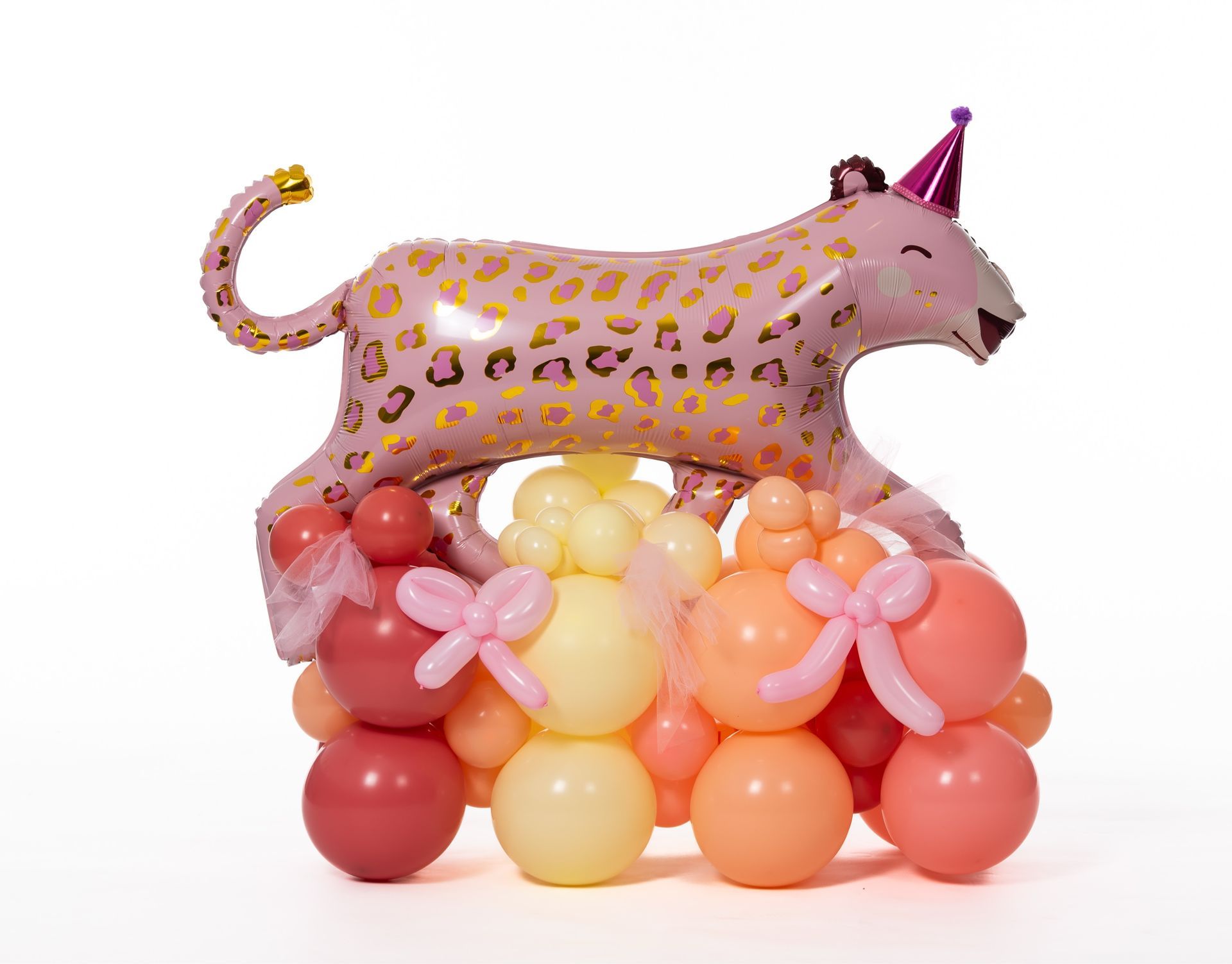 A leopard balloon is sitting on top of a bunch of balloons.