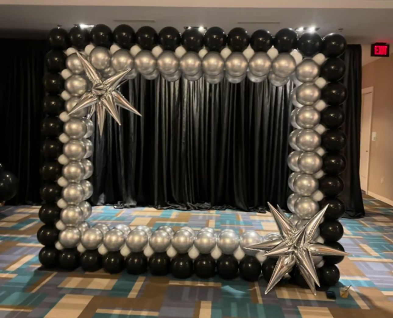 A picture frame made of black and silver balloons