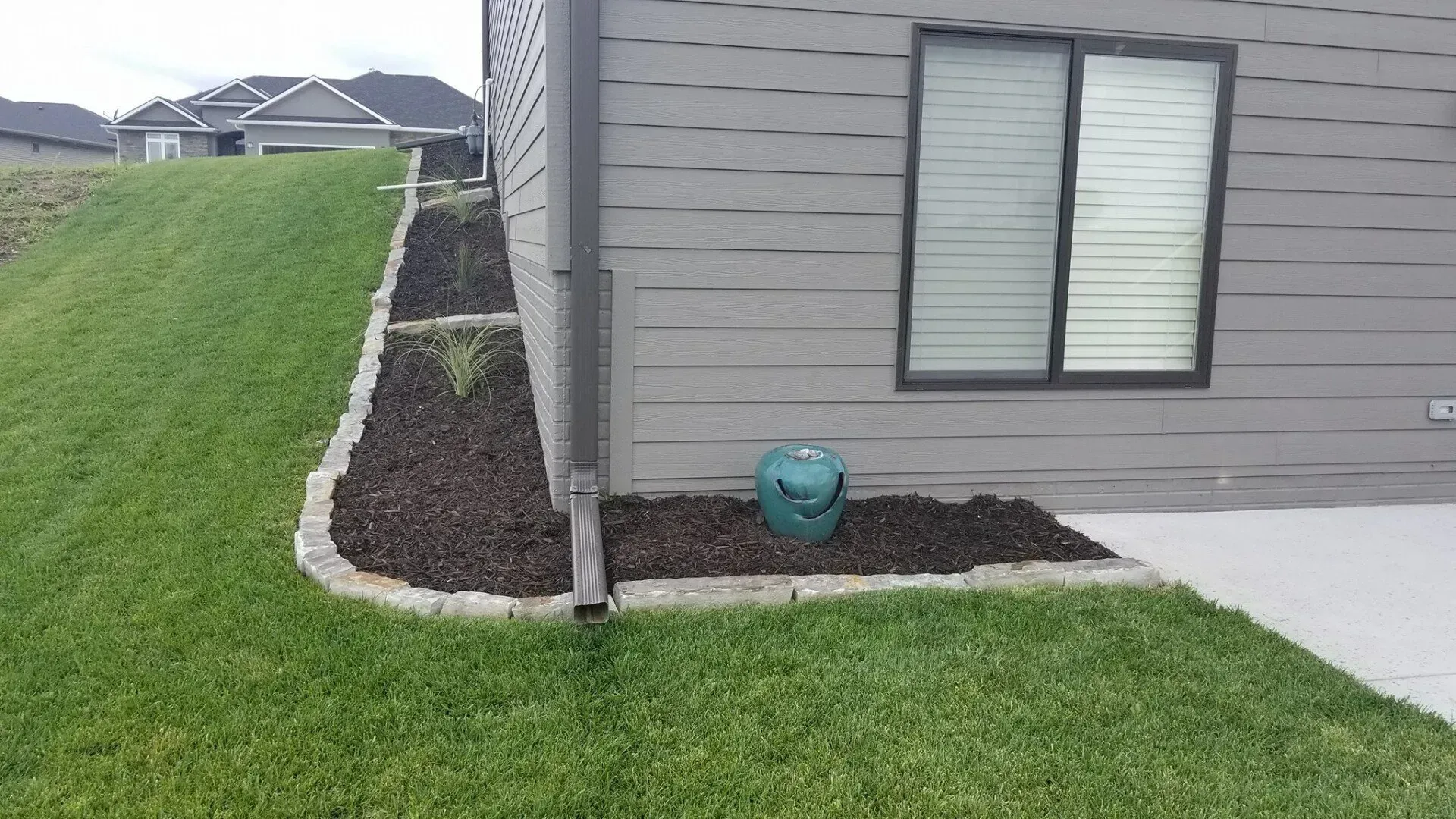The side of a house with a lawn and a window.