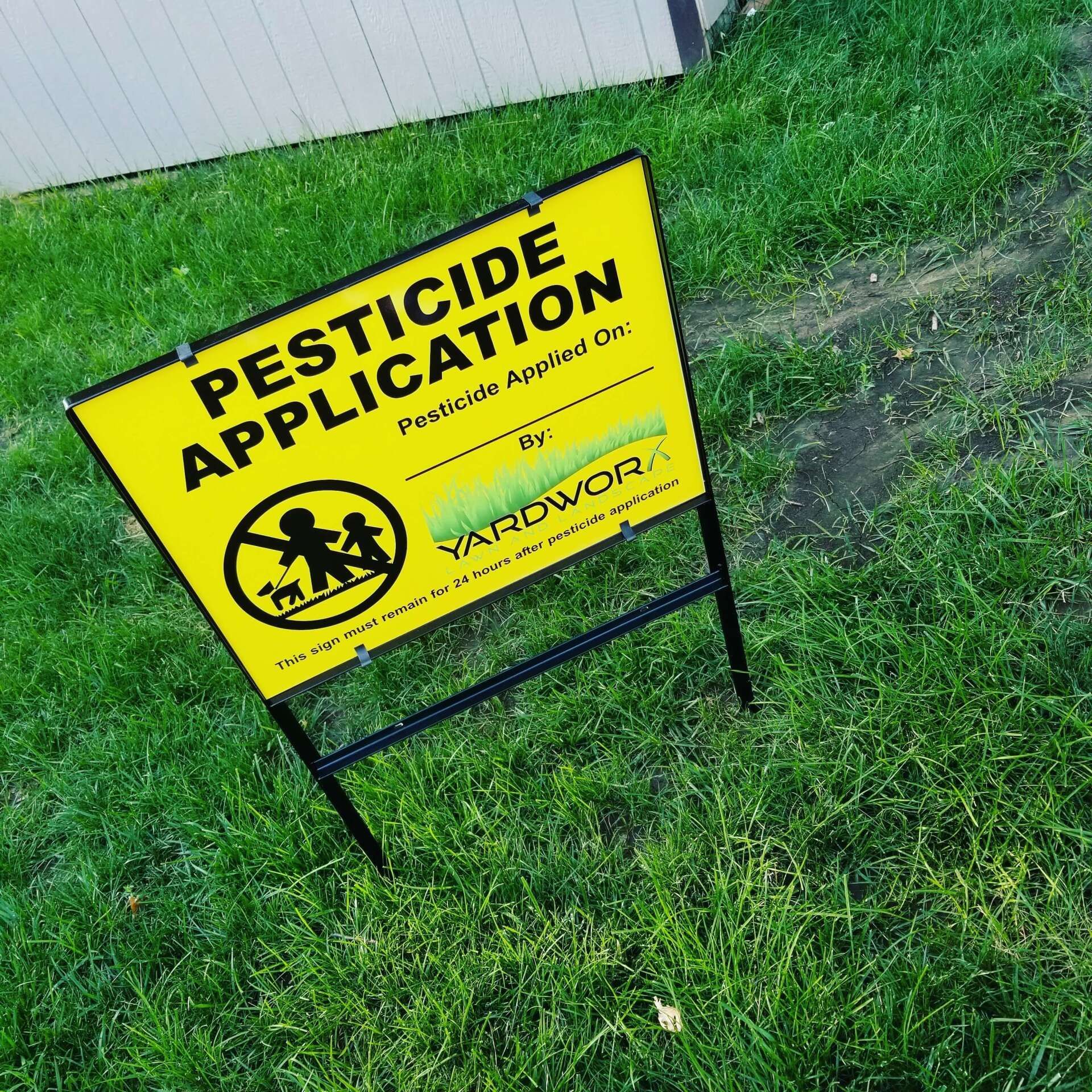 A yellow sign that says ' pesticide application ' on it
