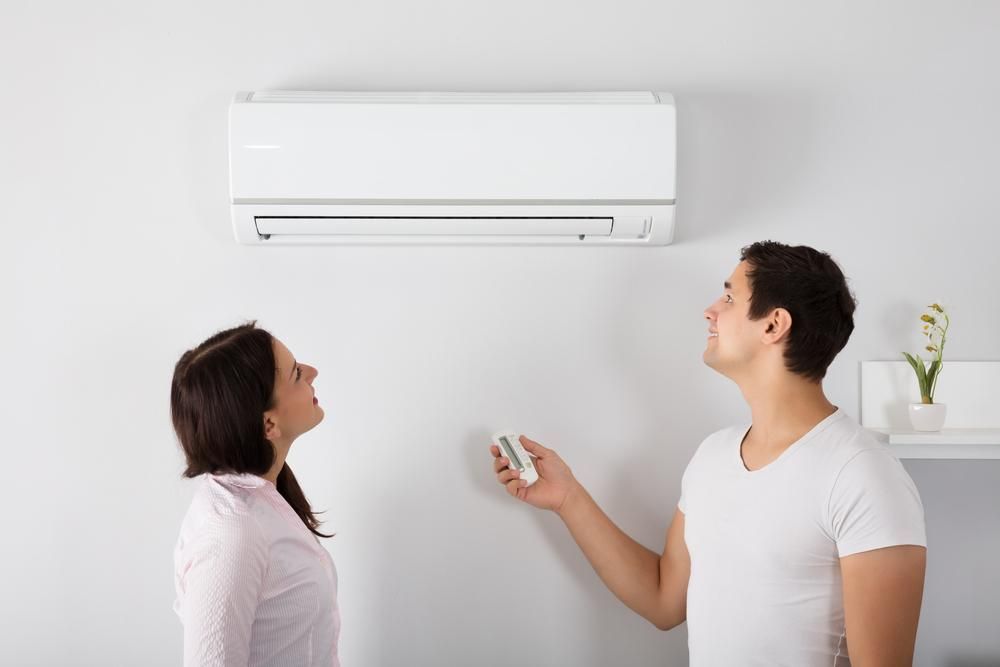 A Man and a Woman Are Standing Next to Each Other — AJM's Air Conditioning Centre in Woodburn, NSW