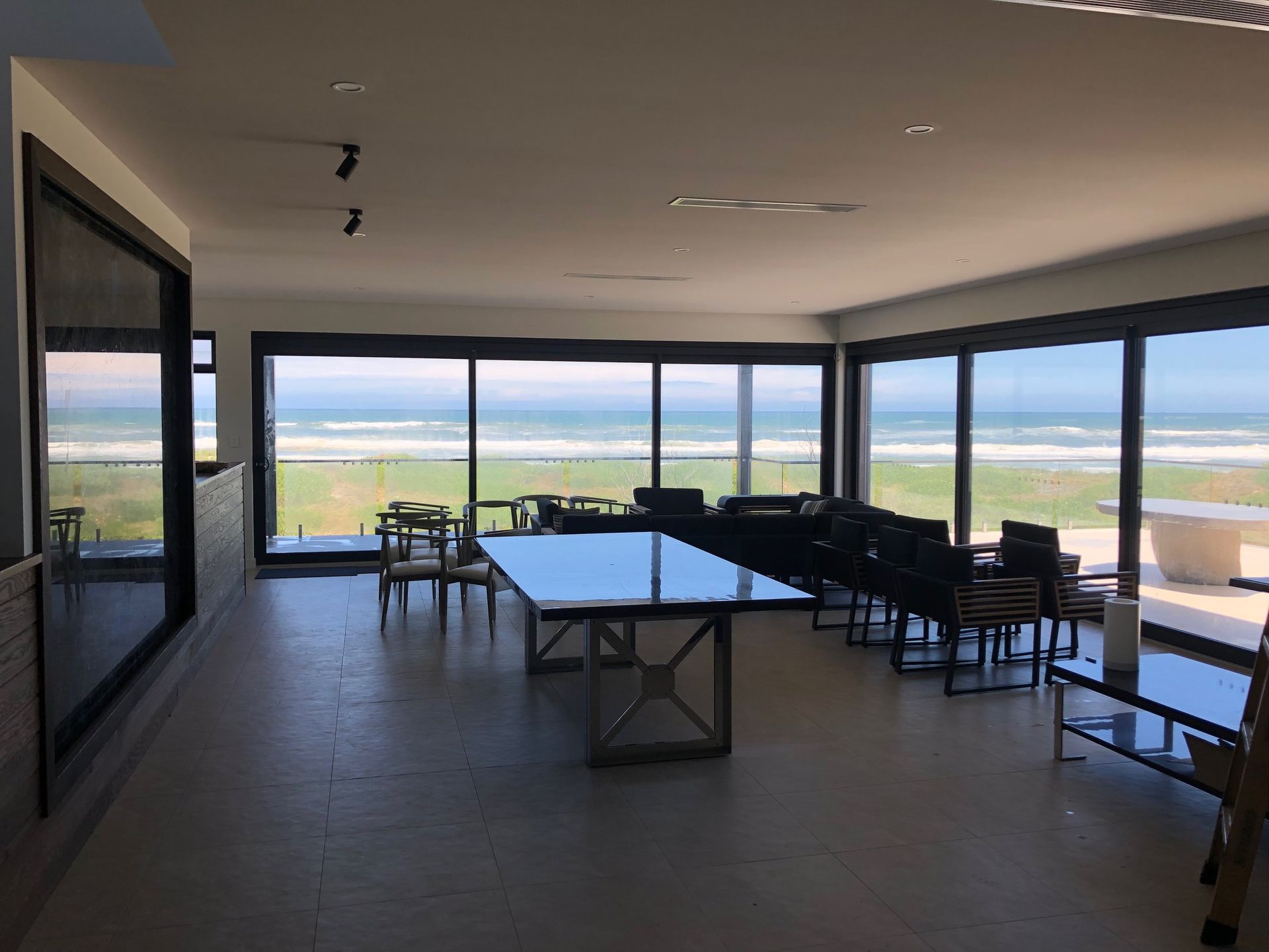 A living room looking over the ocean with a large dinning room table — AJM's Air Conditioning Centre in Lismore, NSW