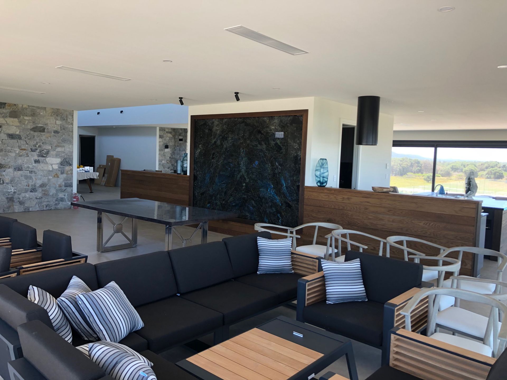 A Large Living Room Area With Black Couches — AJM's Air Conditioning Centre in Lismore, NSW