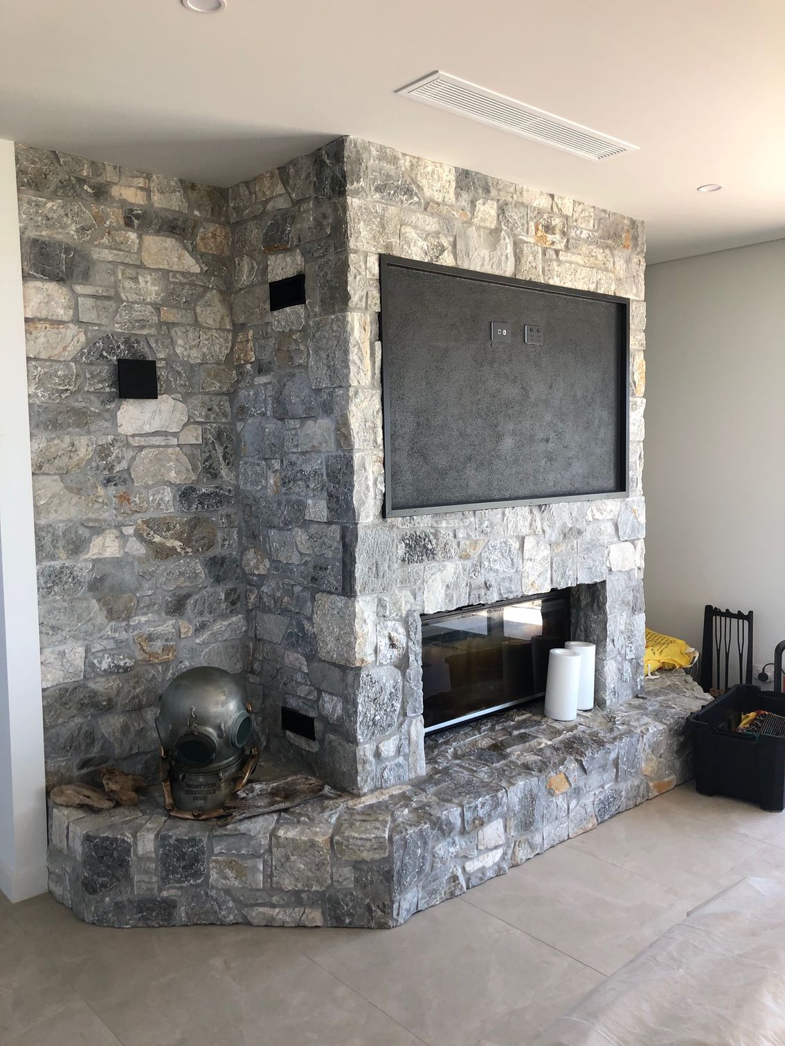 A large stone wall with an air con unit above the wall— AJM's Air Conditioning Centre in Lismore, NSW