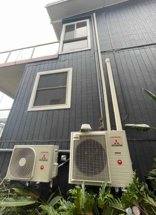 Two Air con units outside a black house — AJM's Air Conditioning Centre in Lismore, NSW