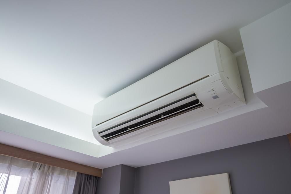 A White Air Conditioner is Hanging From the Ceiling in a Bedroom — AJM's Air Conditioning Centre in Casino, NSW