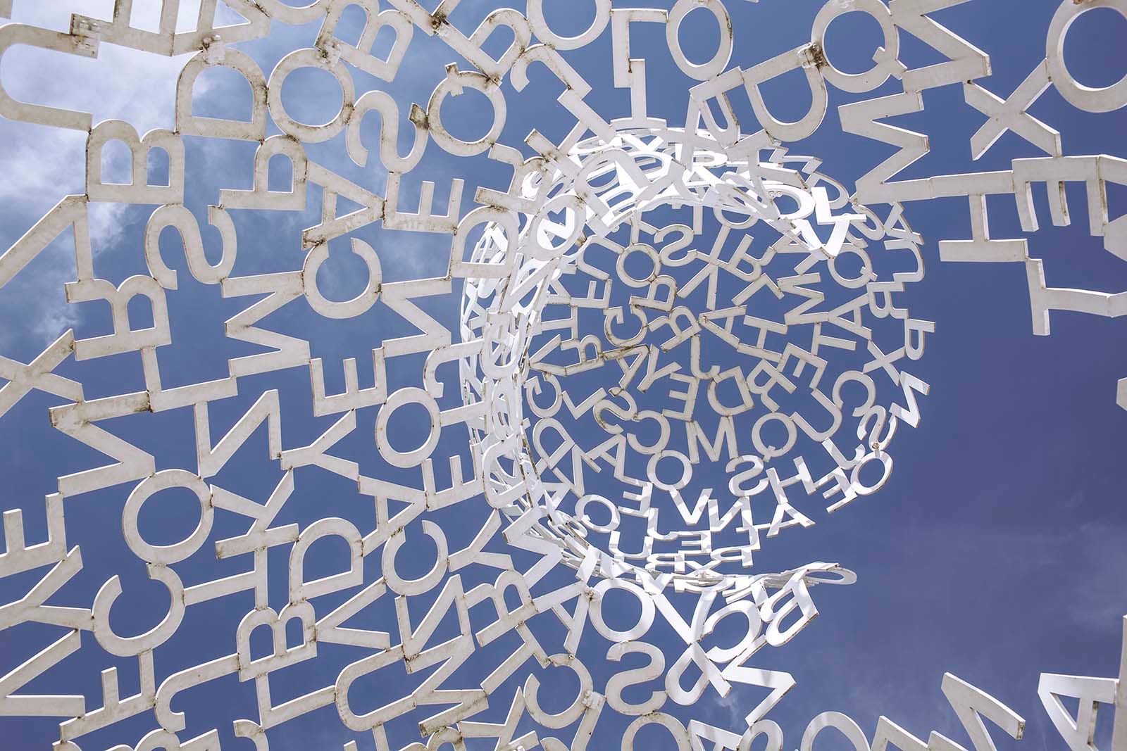 Abstract blue background with a white circular cluster of scattered letters and symbols