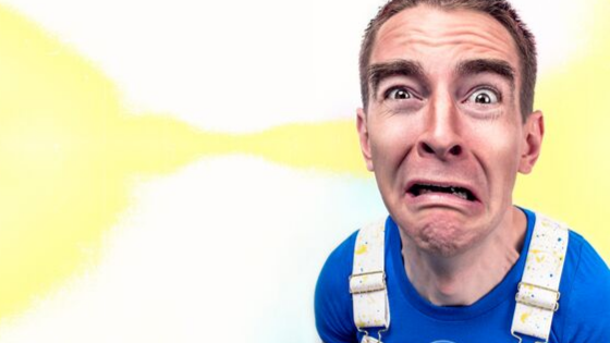 Distorted close-up of a man in a blue shirt with a worried, exaggerated expression against a white background.
