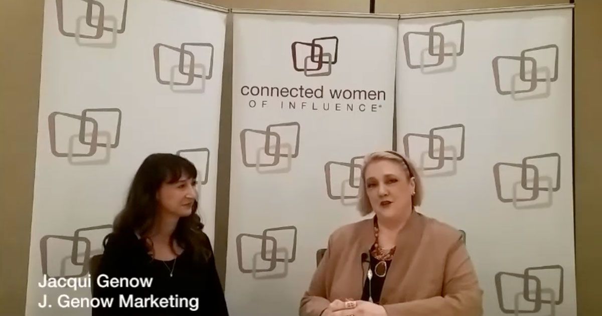 Two women seated in front of a Connected Women logo backdrop during an interview.