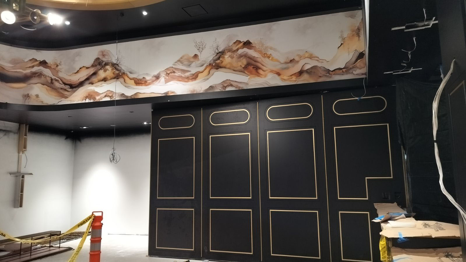 Interior with black paneled wall, white ceiling trim, and a marbled decorative ceiling frieze.