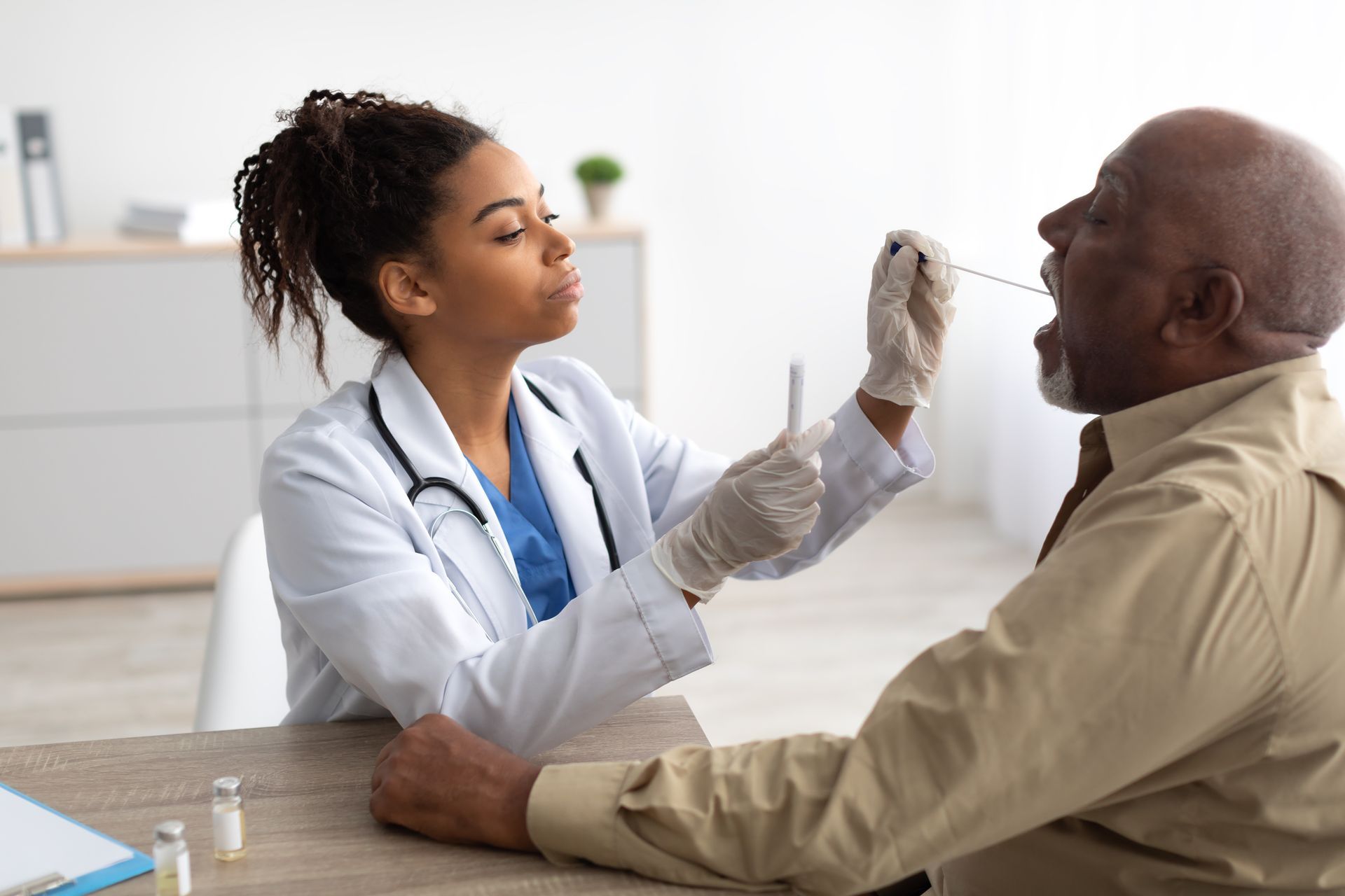 A doctor is taking a sample from a patient 's nose.