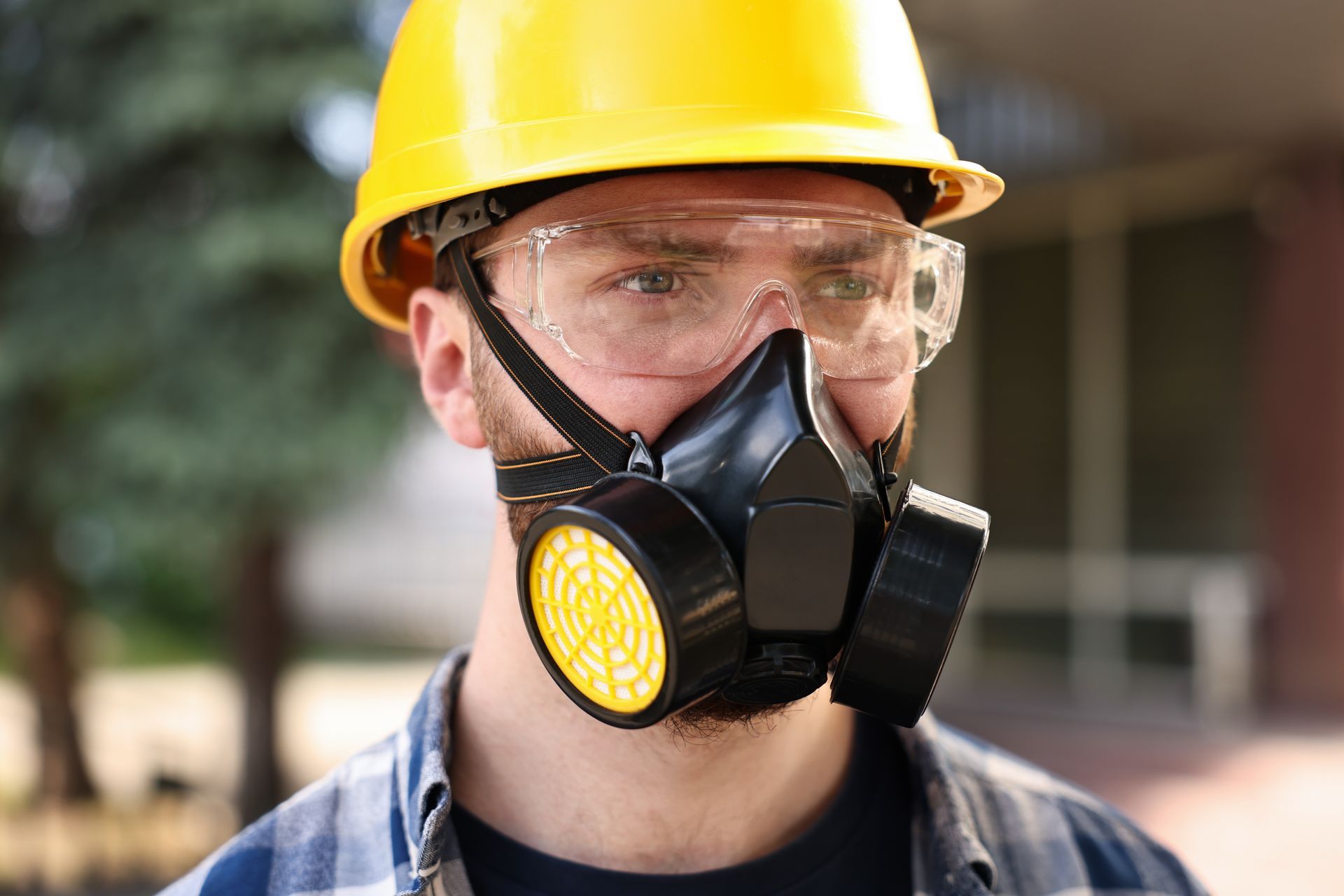 A man wearing a hard hat and a gas mask.