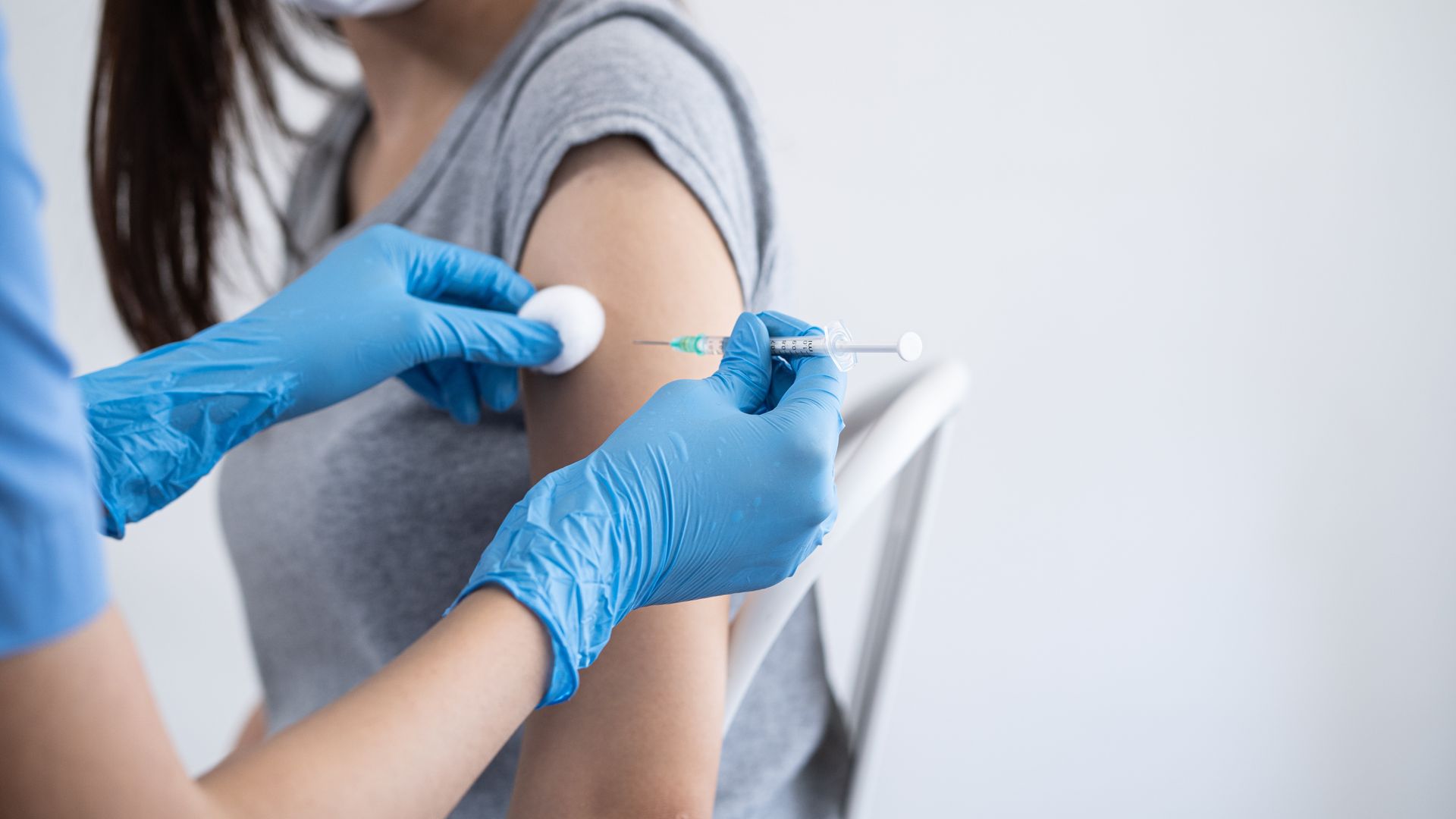 A woman is getting a vaccine in her arm.