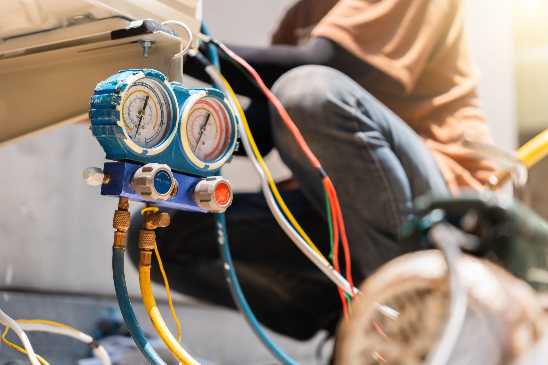 HVAC connected to hoses used for measuring refrigerant pressure during air conditioning maintenance.