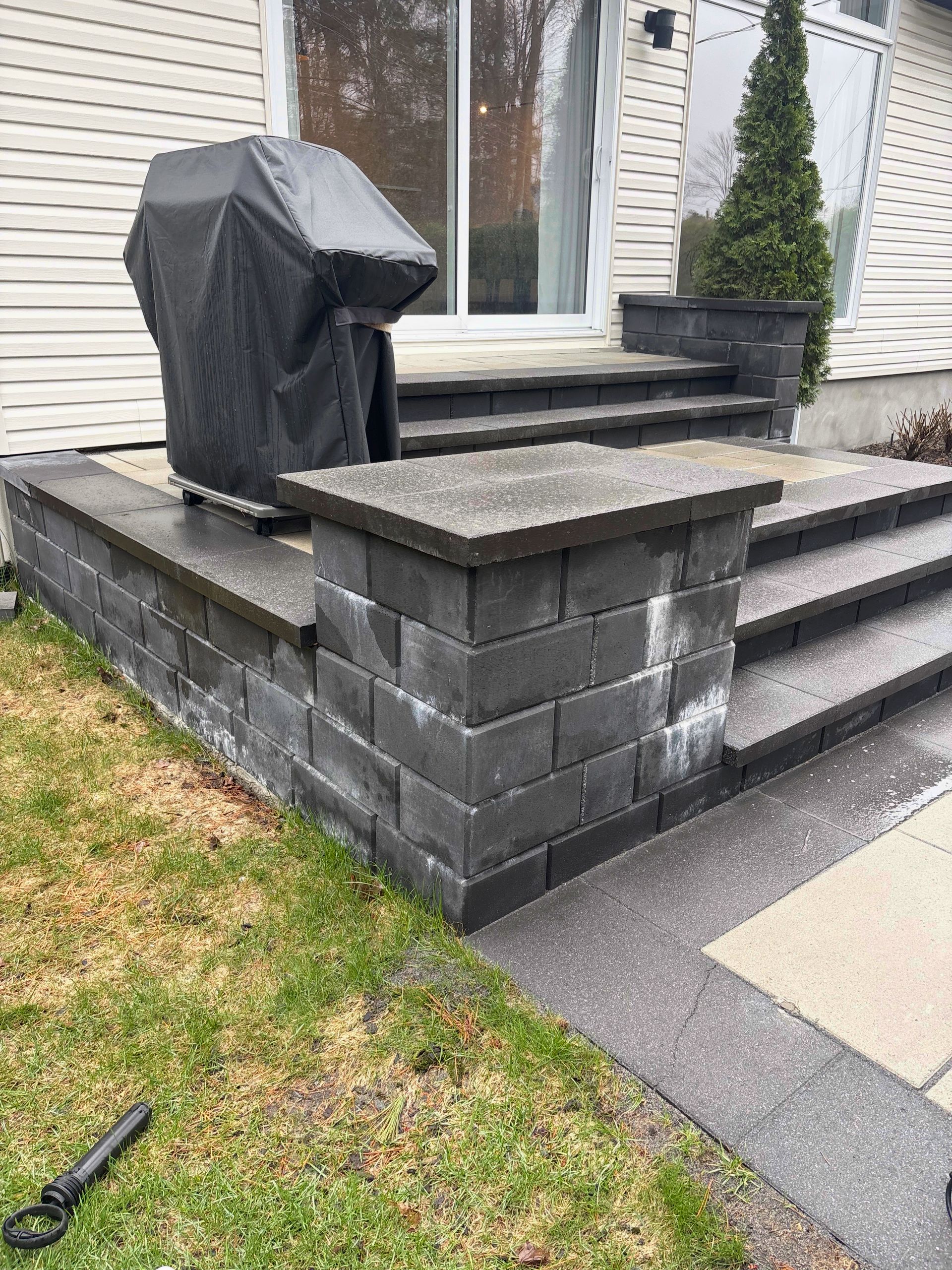 Un escalier menant à une maison avec une rampe rouge.