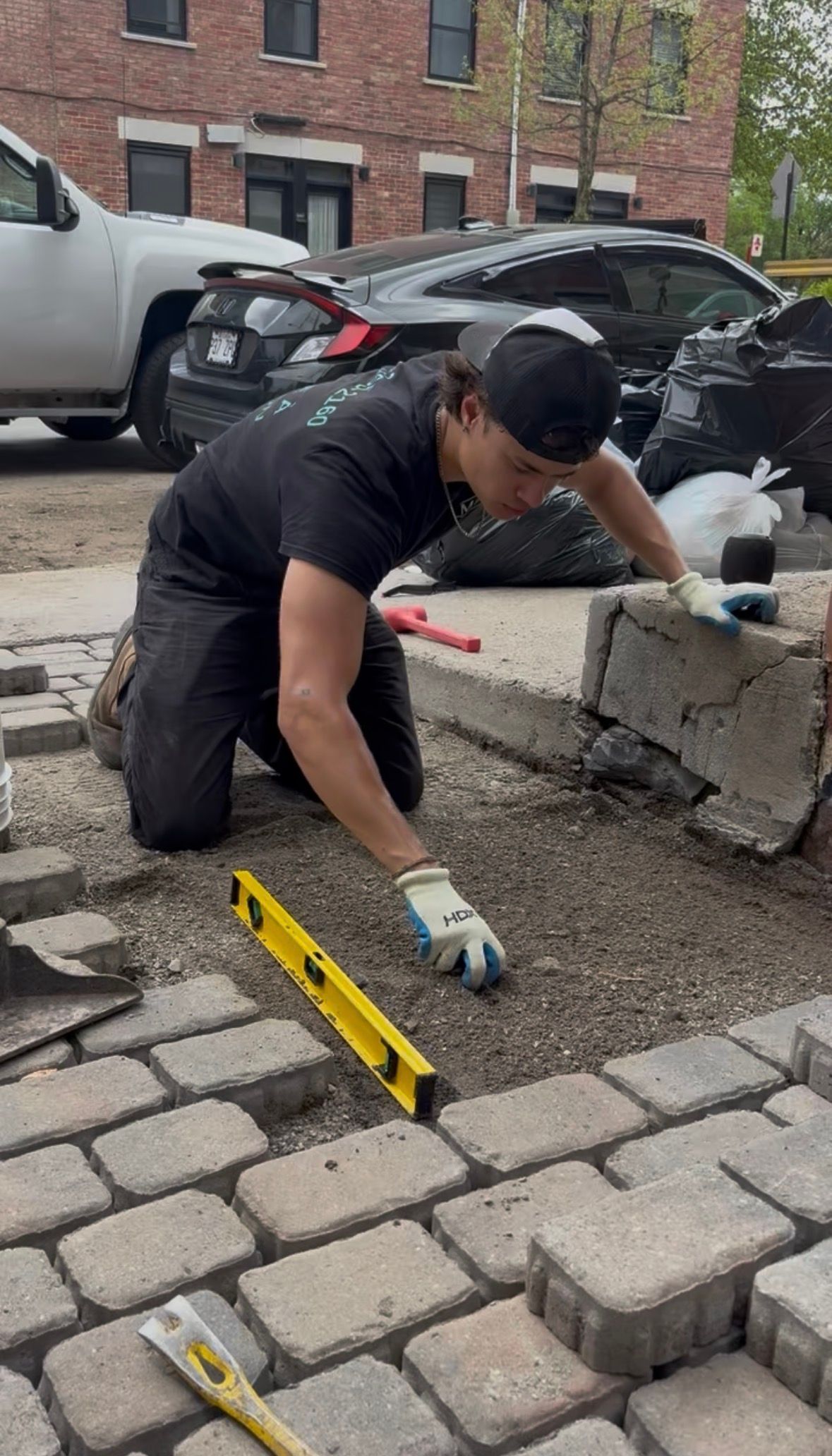 Un homme nettoie un patio avec un nettoyeur haute pression.