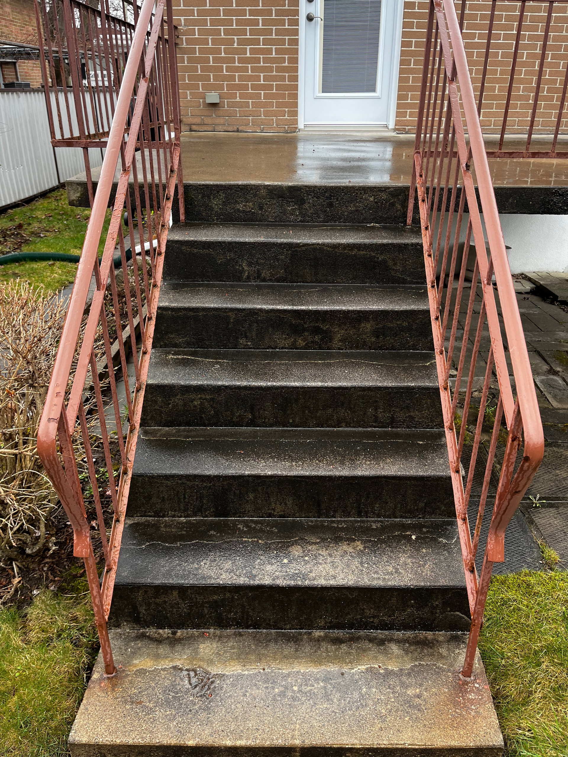 A set of stairs leading up to a house with a red railing.